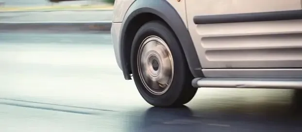 Close-up of van wheels on the road, showcasing the tire treads and the vehicle's sturdy build.