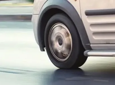 Close-up of van wheels on the road, showcasing the tire treads and the vehicle's sturdy build.