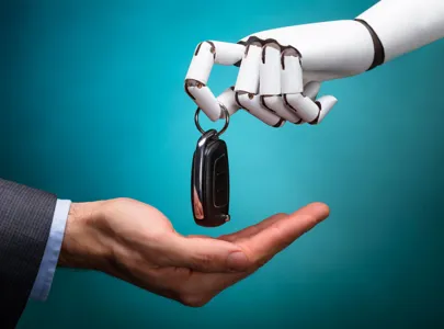 A robotic hand grasping a car key about to drop the key into a male human hand.