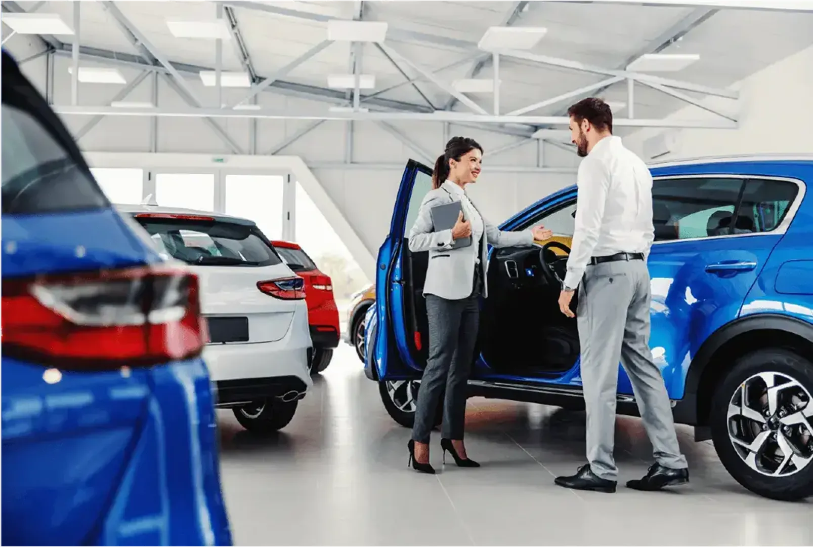 Saleswoman showing a car to a customer
