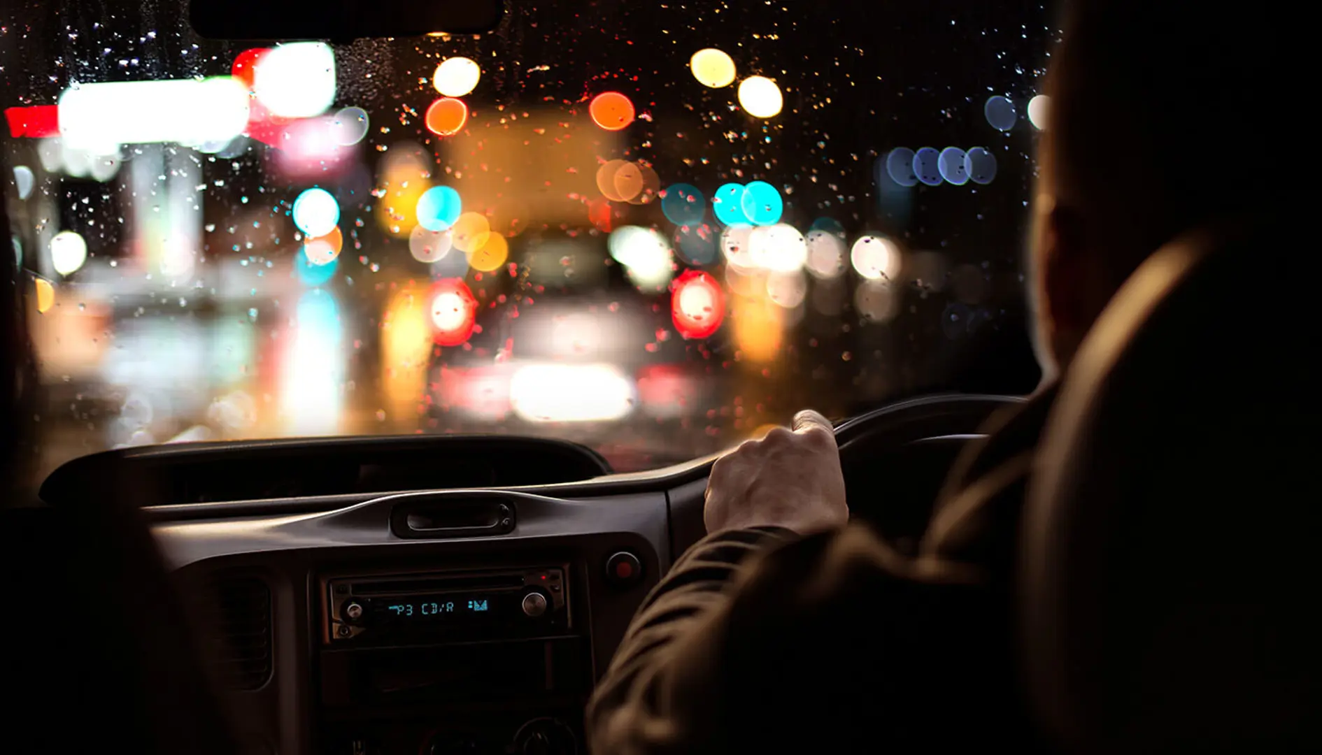 Male driving at night time in the rain.