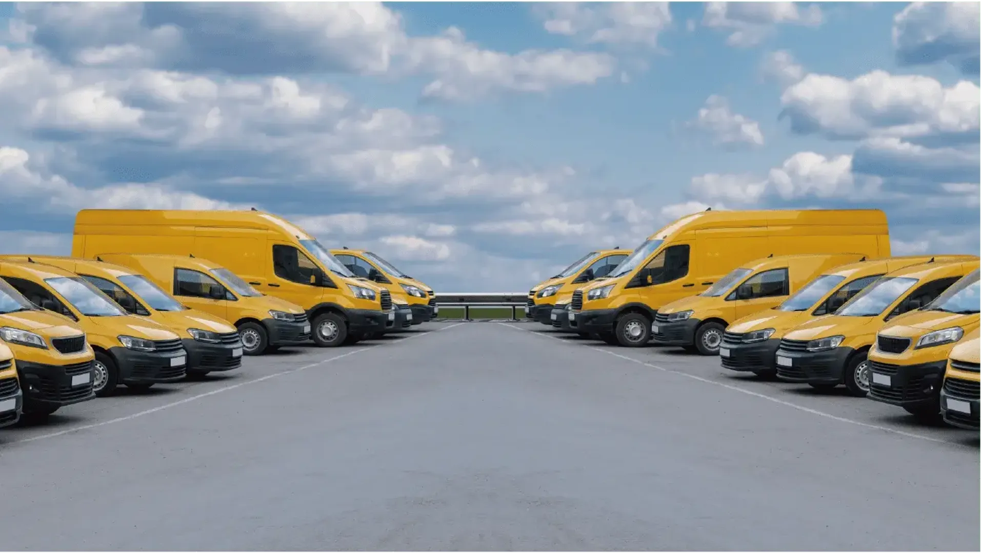 A line of yellow vans parked in a parking lot, ready for use.