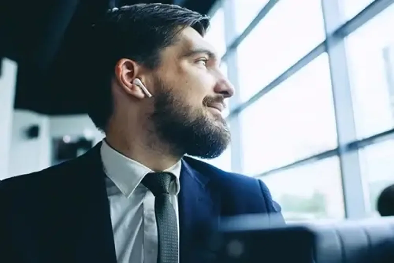 Man with earphone in looking out the window