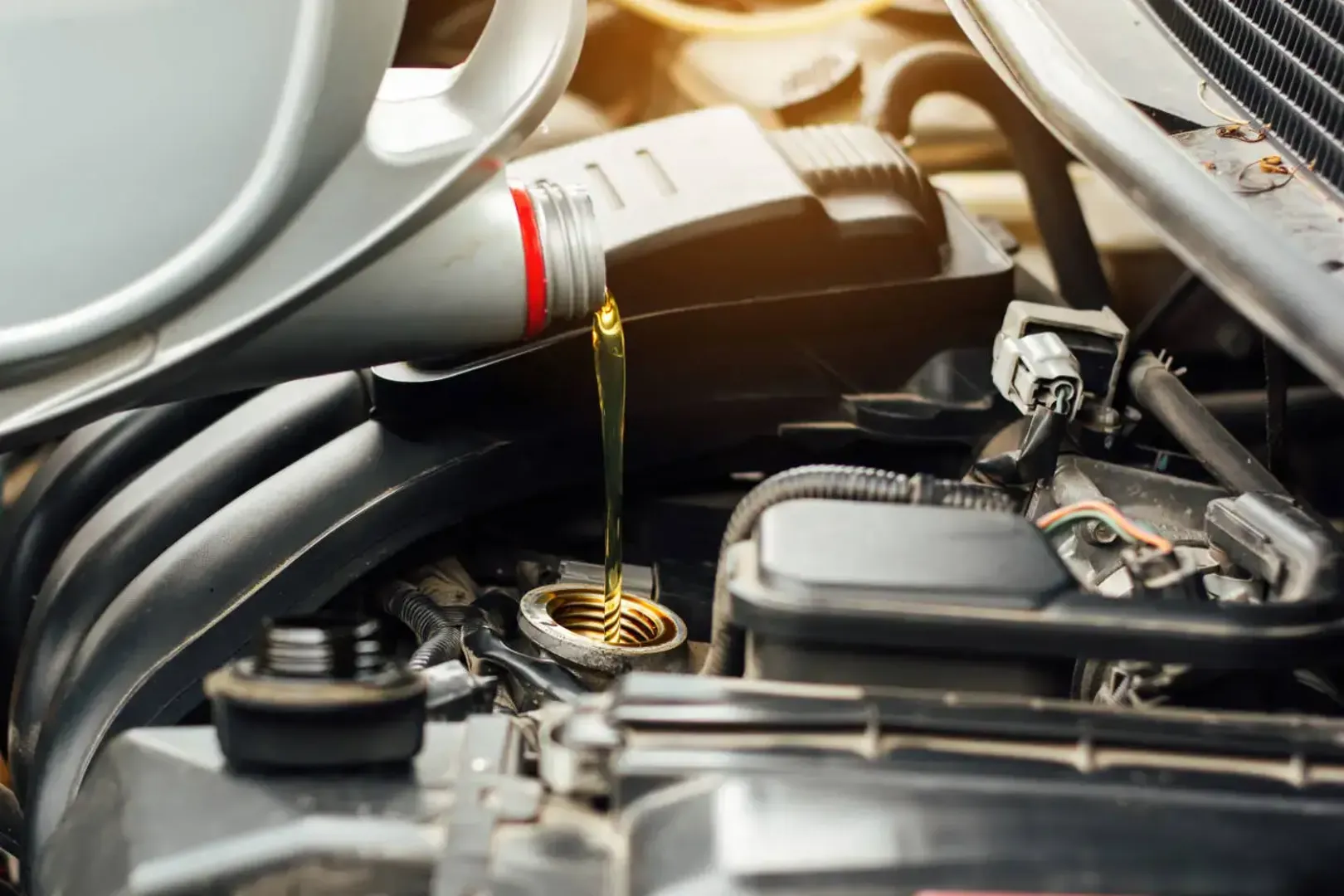 A car engine being filled with oil, ensuring proper lubrication and smooth operation.