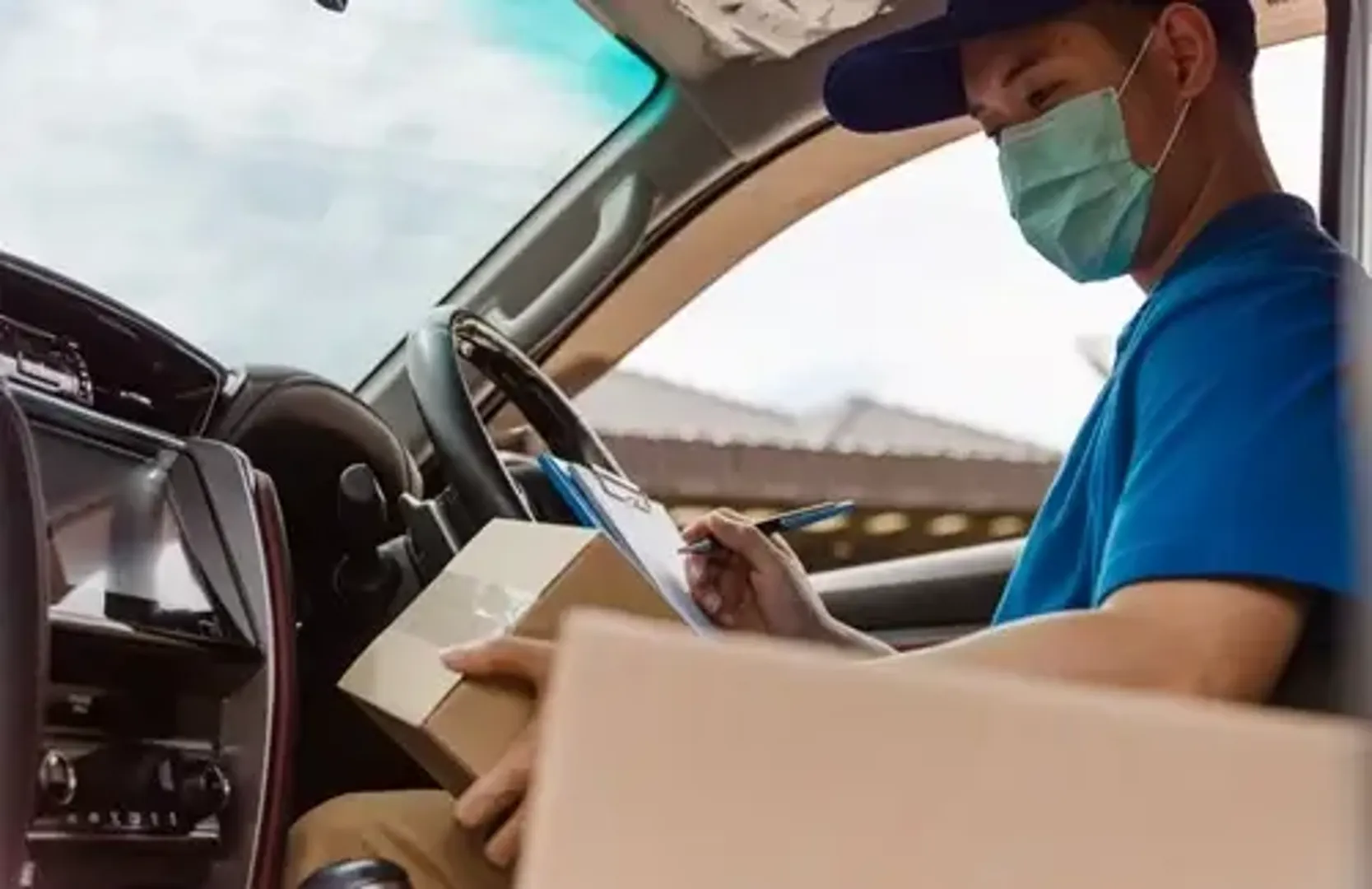 Delivery driver in car wearing a face mask