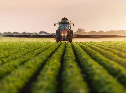 A tractor spraying crops in a field, ensuring efficient and effective distribution of pesticides.