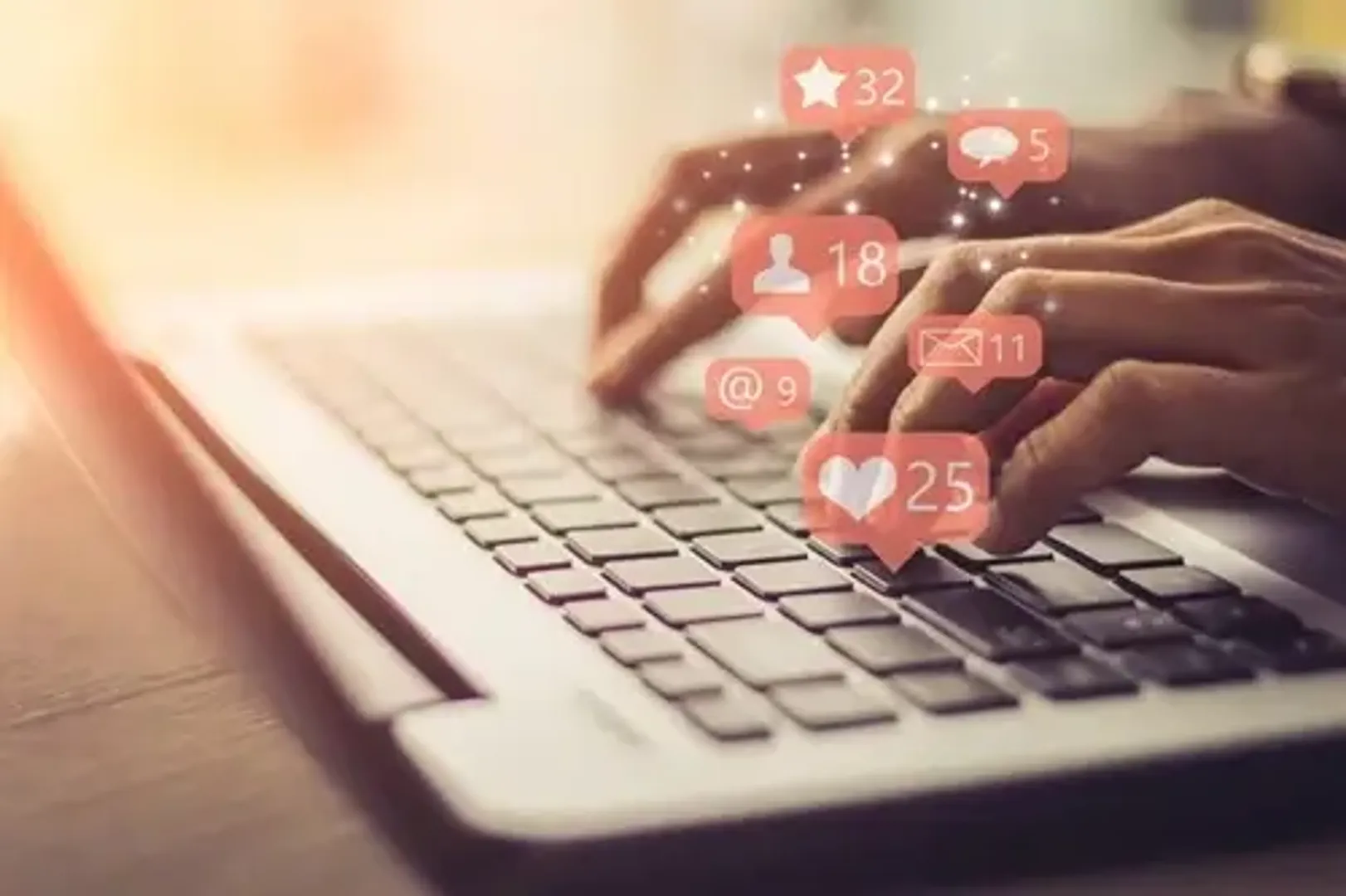 Image of hands on laptop keyboard with social media icons, representing social media