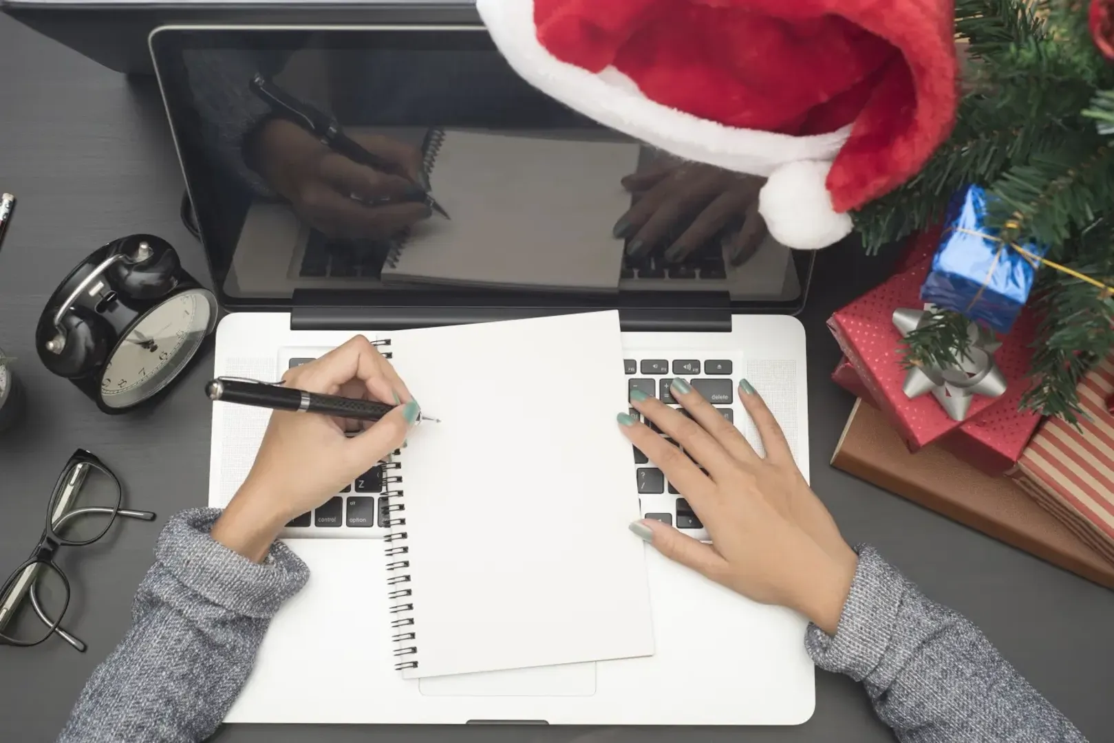 Desk with a laptop with a Christmas hat on it