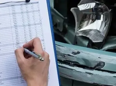 A man inspecting a damaged car, taking notes on a clipboard.